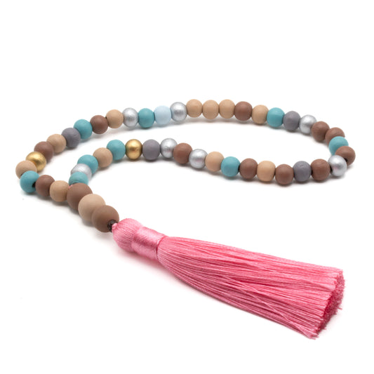 Mala de 45 cuentas de madera multicolor con borlón rosa, ritualizado para meditación y equilibrio energético.