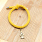 Pulsera Nazareno Católica Amarilla con cordón elástico y figura de nazareno cristiano
